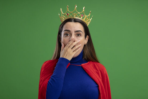 皇冠年轻的超级英雄女孩戴着王冠 嘴上戴着绿色的隔离手套掩护超级英雄害怕