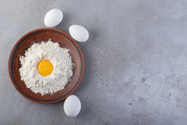 新鲜生鸡蛋放在石头表面上母鸡生的未煮熟