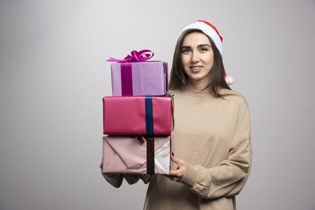 人年轻女子拿着三盒圣诞礼物女性表情圣诞老人