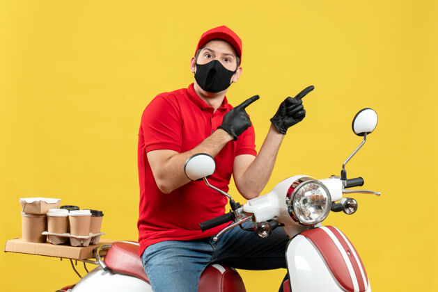 摩托车顶视图好奇的信使家伙穿着红色上衣 戴着帽子手套 戴着医用口罩 坐在滑板车上指点着什么滑板车车辆命令