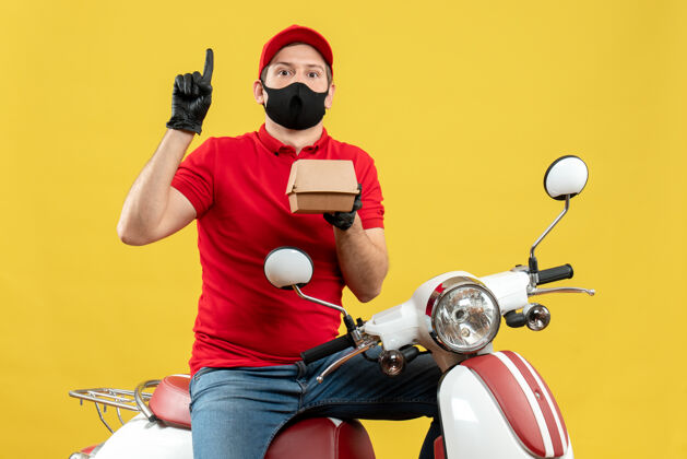 摩托车顶视图送货员穿着红色上衣 戴着帽子手套 戴着医用面罩 坐在滑板车上 显示订单指向上送货员指向手套