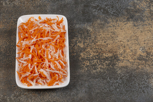 切片白盘子里放着美味的卷心菜和胡萝卜烹饪自然食物