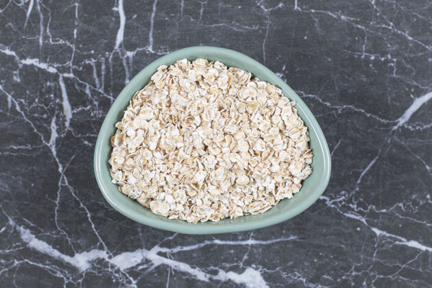 膳食把燕麦或燕麦片放在石头上的木碗里小麦有机玻璃