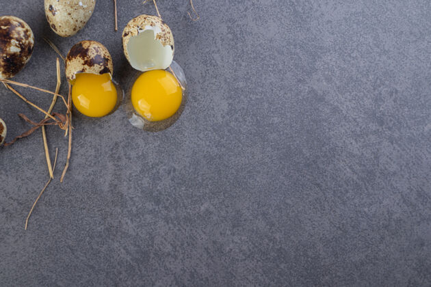 美食石桌上放着一堆生鹌鹑蛋和蛋黄顶视图鸡蛋食物