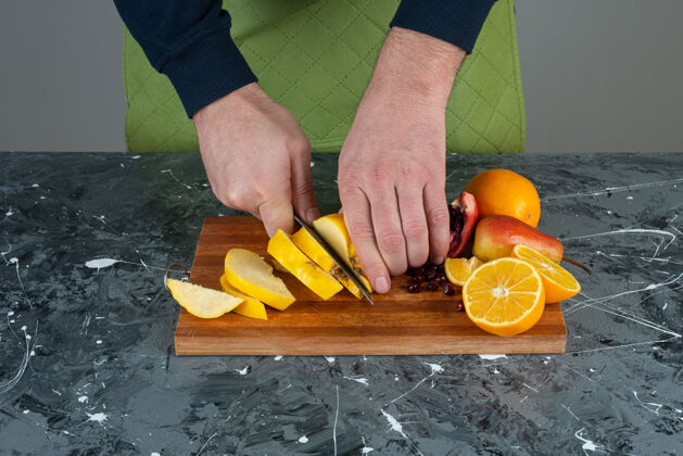 男男手切熟透的木瓜放在桌上的木板上橙子手烹饪