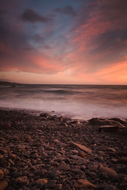 日落在日落的背景下拍摄一个岩石海滩的惊险镜头美丽黄昏岩石