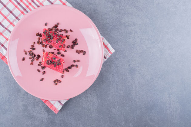 晚餐土耳其美食rahatlokum和粉红色盘子上的干葡萄干的顶视图糖果自然柠檬