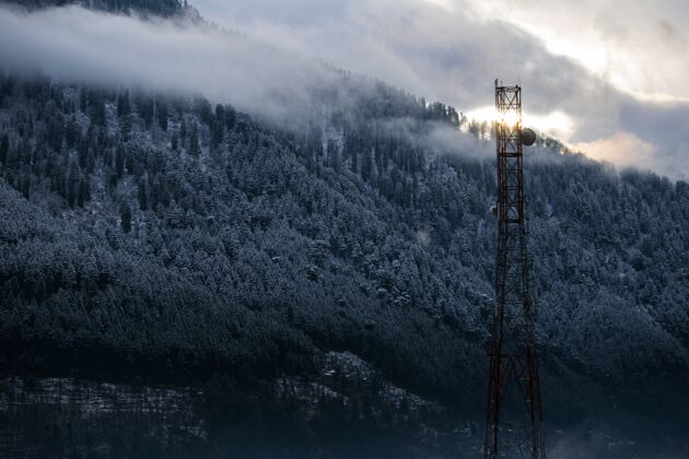 钢美丽的拍摄一个广播塔在雪域森林的背景风景通信美丽