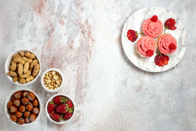 食品白色表面上有榛子和花生和草莓的顶视图新鲜核桃水果