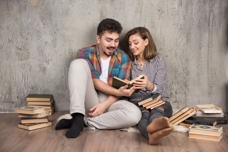 学习坐在地板上看书的年轻夫妇阅读男性锻炼