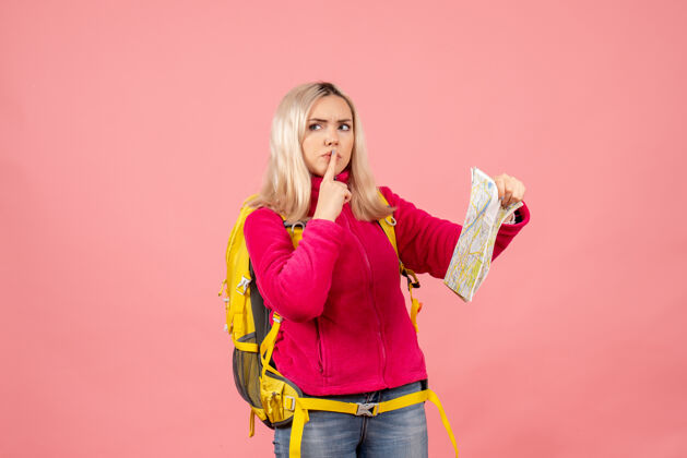 可爱前视图困惑的旅行妇女与黄色背包举行地图制作安静的标志前面肖像持有