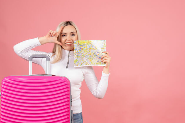 快乐正面图漂亮的女人拿着粉红色的手提箱举着地图欢呼人持有