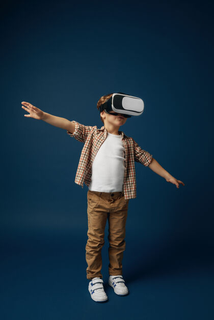 现实在天空中失重小男孩或儿童在牛仔裤和衬衫与虚拟现实耳机眼镜隔离在蓝色的工作室背景尖端技术的概念 视频游戏 创新视频游戏游戏科技