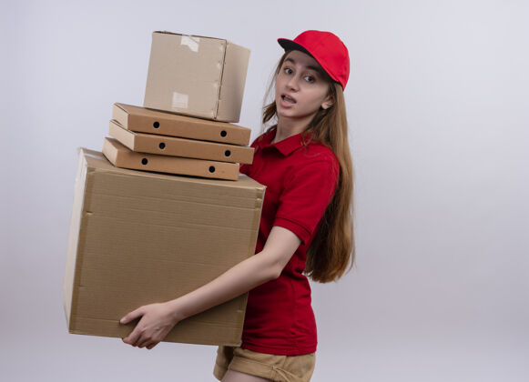交付令人印象深刻的年轻送货女孩在红色制服举行包裹和箱子上孤立的白色空间与复印空间红色印象空间