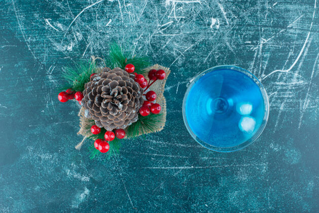 美味一个大的圣诞松果和一杯蓝色饮料蓝色顶视图可口