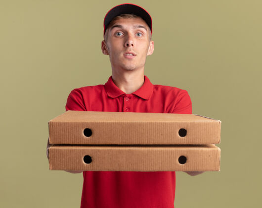 年轻令人印象深刻的年轻金发送货男孩举行披萨盒橄榄绿送货橄榄印象