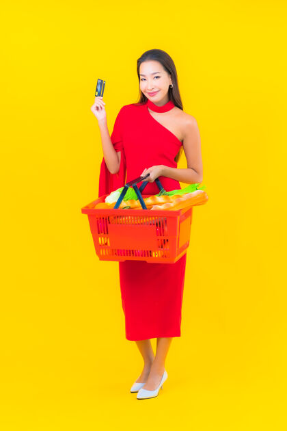 消费主义从超级市场拿着购物篮的美丽亚洲年轻女子的画像选择美丽信用卡