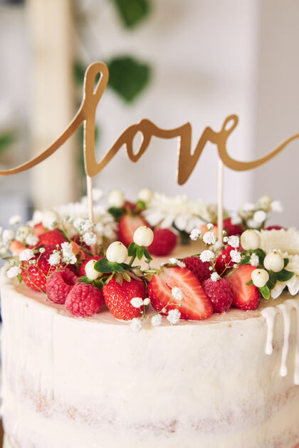 婚礼精选焦点拍摄美味的白色婚礼蛋糕与红色浆果 鲜花和蛋糕顶水果顶级食物