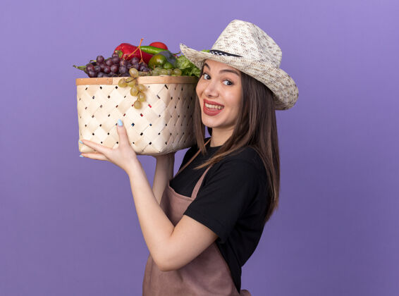 帽子笑容可掬的白人女园丁戴着园艺帽捧着紫色的菜篮子园艺女漂亮
