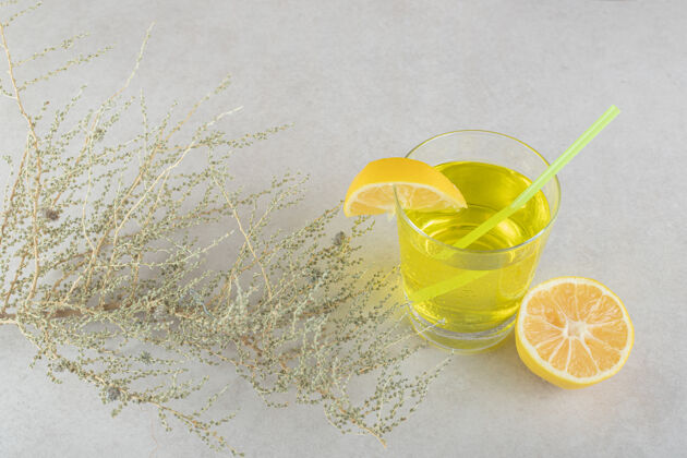 玻璃一杯柠檬水 柠檬和稻草放在灰色的表面上柠檬膳食水果