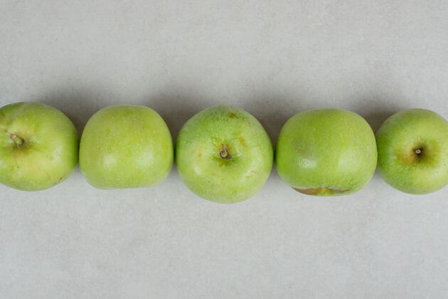 生的整个青苹果在灰色的表面上配料可口熟的