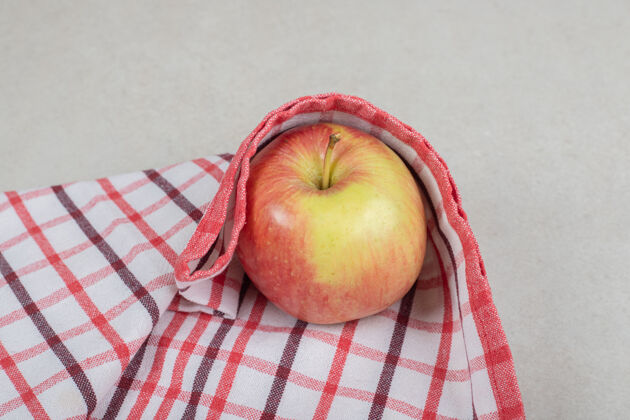 配料整个红苹果在条纹桌布上熟的有机桌布