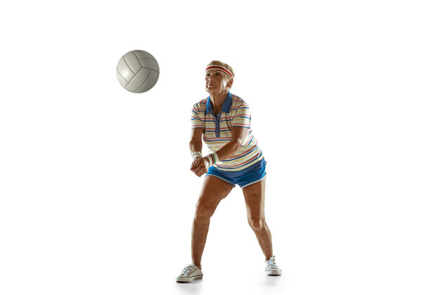微笑穿运动服的高级女士在白色背景下打排球身材魁梧的白人女模特保持活跃运动 活动 运动 健康 自信的概念复制空间球拍姿势业余