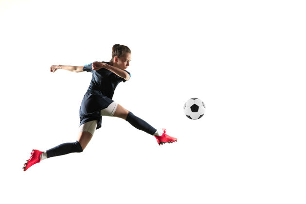 衣服年轻的女足球运动员或足球运动员 长发 运动服和靴子 为目标踢球 跳跃 白色背景健康的生活方式 职业体育 爱好的概念室内设备球