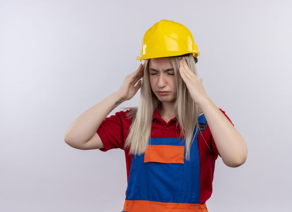 工程师疼痛的年轻金发工程师建筑工女孩穿着制服头痛把双手放在太阳穴闭上眼睛在孤立的空白空间与复制空间制服封闭复制