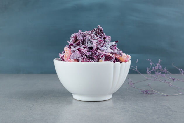 盘子切碎的紫洋葱和卷心菜沙拉放在陶瓷杯里灰色晚餐午餐