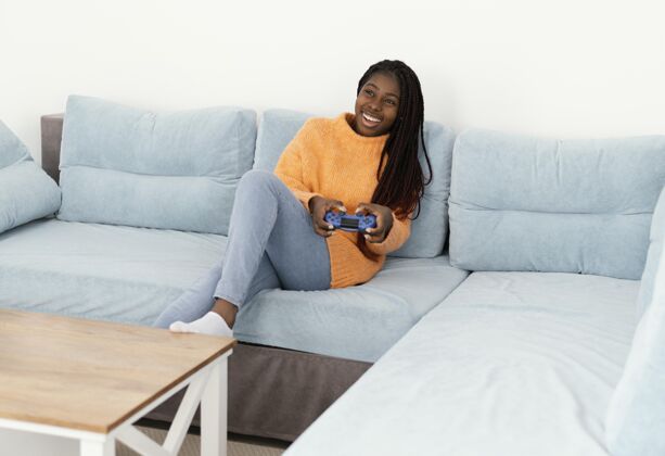 控制器笑脸女孩在沙发上玩电子游戏休闲视频游戏全拍摄