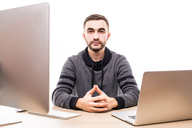 一个自信的年轻企业家坐在桌边 拿着笔记本电脑和个人电脑 看着隔离在白色屏幕上的相机报告笔记本电脑年轻人