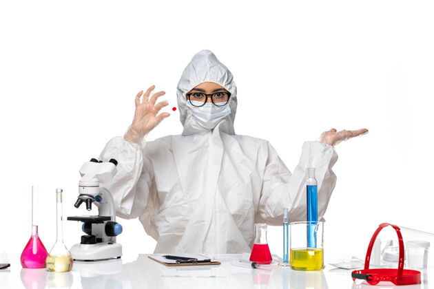 西装前视图穿着特殊防护服的女化学家拿着浅白色背景上的样本化学冠状病毒大流行药医学持有