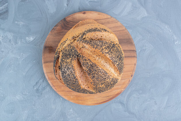 面团一块黑芝麻下的木板铺在大理石桌上面包盖面包美味