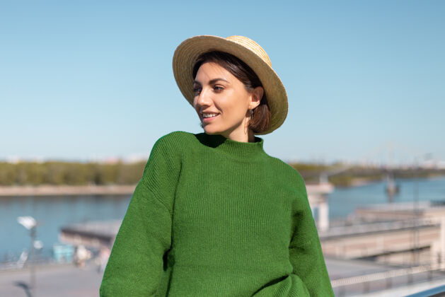 桥梁穿着绿色休闲毛衣 戴着绿色帽子的时尚女性 户外桥上 河景 享受夏日阳光明媚的日子 欢快 快乐 快乐 积极向上的氛围 捕捉阳光牛仔裤蓝色模型