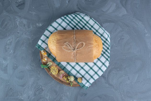 领带把面包包好绑在木板上 用毛巾铺在大理石桌上面包屑可口包装