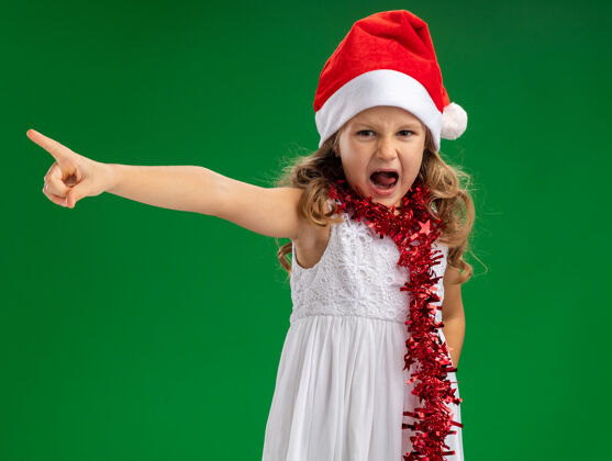 绿色愤怒的小女孩戴着圣诞帽 脖子上有花环 边上有绿色的背景壁板帽子脖子