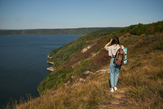乌克兰背着背包走在高高的青山上的女人水徒步旅行河流