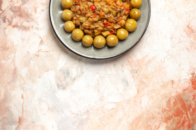 李子烤茄子沙拉和腌李子在裸体表面上的盘子俯视图水果营养素食