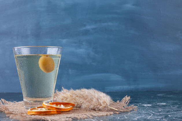 新鲜新鲜的鸡尾酒和成熟的金橘放在石头背景上新鲜金橘玻璃