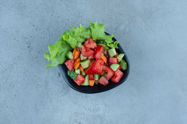 生菜一碗放在大理石表面的羊肉沙拉黄瓜番茄美味