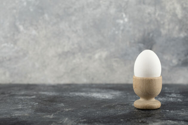 新鲜一个木制的鸡蛋杯 里面有煮熟的鸡蛋饮食动物颜色