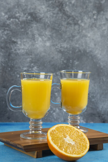 马克杯在木板上放两杯橙汁橙子美味冰沙
