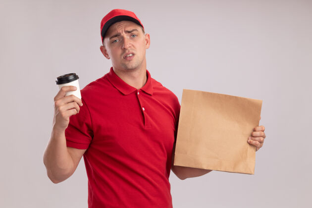 帽子年轻的送货员穿着制服 戴着帽子 手里拿着一个纸食品包 白墙上隔着一杯咖啡食物制服送货