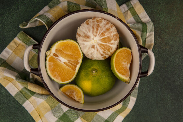 检查新鲜健康的橘子在一个格子布碗顶视图健康衣服顶部