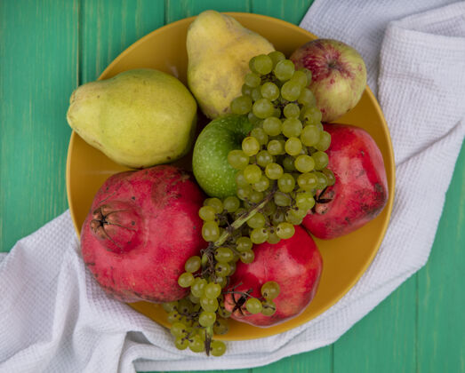 梨顶视图石榴与梨苹果和葡萄在一个盘子里有机健康盘子