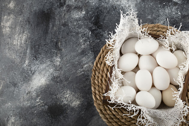 食品一个装满白色生鸡蛋的木篮营养蛋壳整个