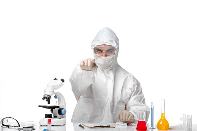 药正面图男性医生穿着防护服 戴着面罩 因为科维德只是坐在白色空间观点化学坐