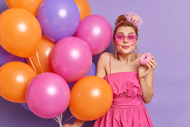 女孩美丽喜庆的红发女青年高兴地看着镜头玩得开心 庆祝节日女性年轻气球