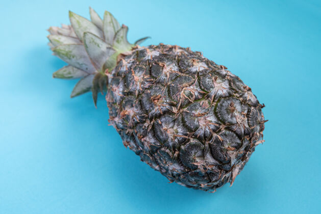 细节蓝色表面上的菠萝五颜六色素食夏季